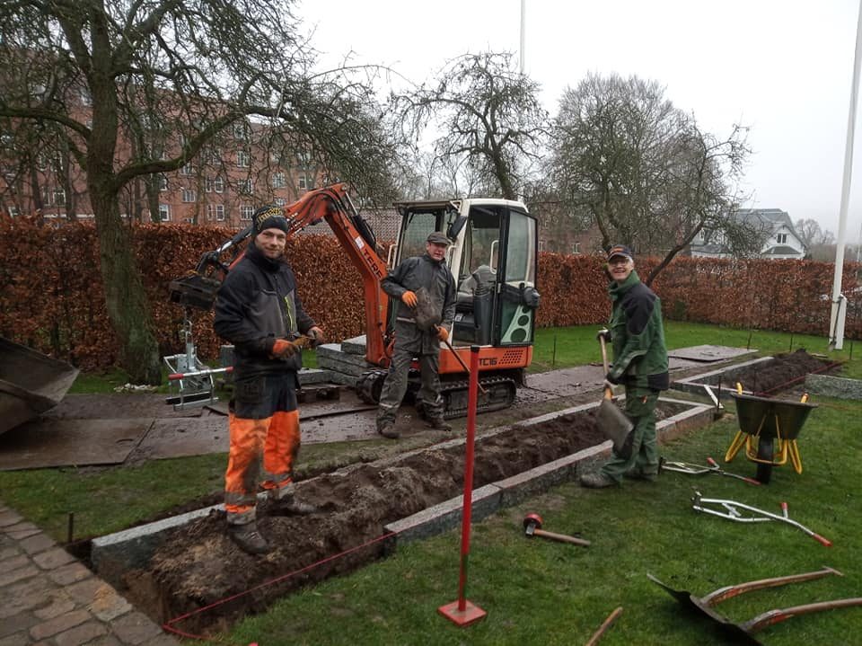 Anlægsgartnere med minigraver anlægger et bed med kantsten